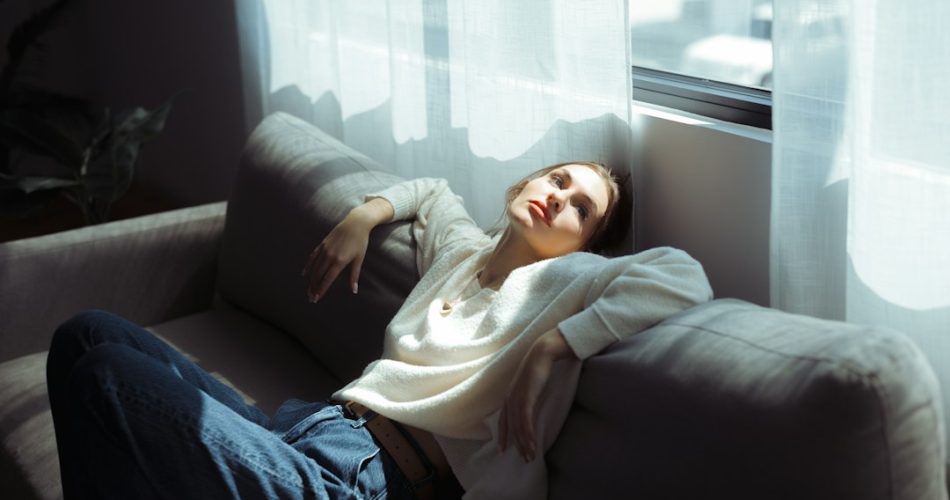 Woman taking a short daytime nap on a sofa in natural daylight